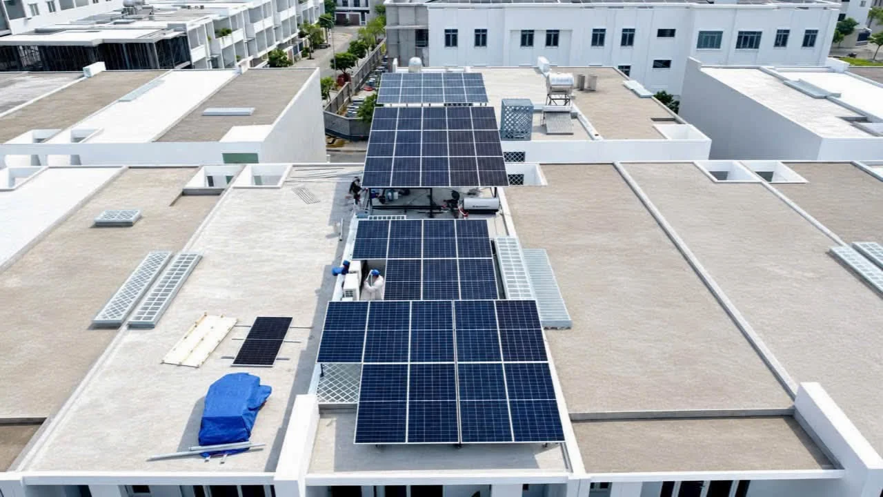 Các cụm tấm pin phân bố theo chiều dài sân thượng, xen giữa những thiết bị và khoảng mái hiện hữu.
